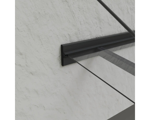 Detailný pohľad na sklenené zastrešenie vchodových dverí s tmavým rámom na stene