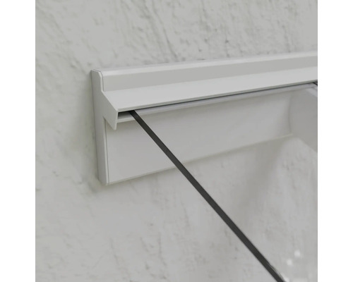 Detail sprchovacieho kúta s bielym rámom a sklenenou stenou