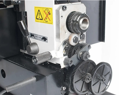 Detailný záber sústruhu s ozubenými kolesami a pákami.