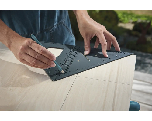 Osoba kreslí čiaru ceruzkou a multifunkčným uholníkom na drevenej doske