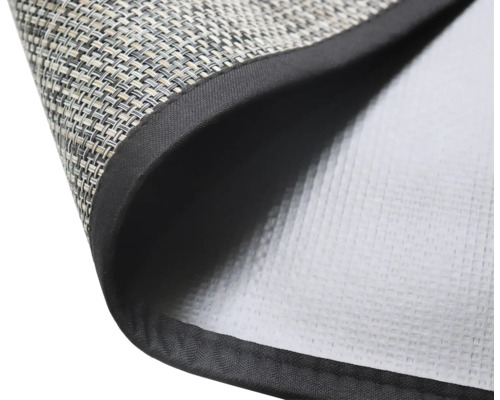 Detailný pohľad na prestieranie s tkaným povrchom a látkovým okrajom