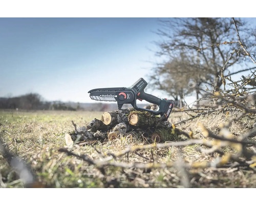 Akumulátorová reťazová píla Metabo na kmeni stromu v záhrade