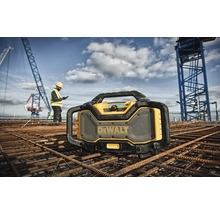 Stavebné rádio DeWalt na stavenisku so stavebným robotníkom a žeriavom v pozadí
