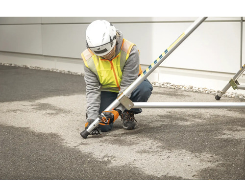 Osoba montuje lešenie s vyrovnávacími pätkami.