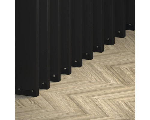 Detailný záber čiernych lamiel na parketách so vzorom rybej kosti