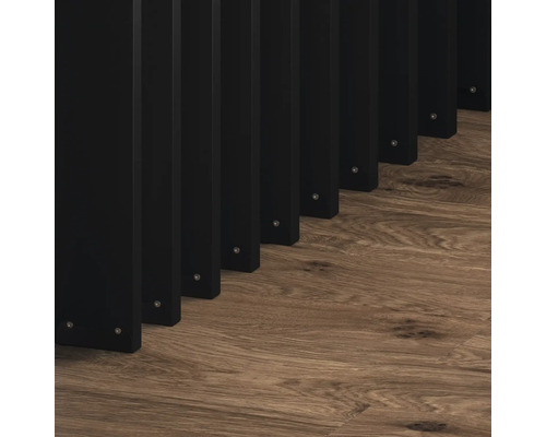 Čierny drevený lamelový plot na drevenej podlahe