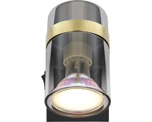 Nástenné svietidlo s valcovým tienidlom a zapnutou žiarovkou.