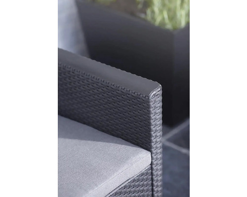 Detailný záber záhradnej stoličky so sivým vankúšom a ratanovou pleteninou.