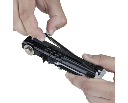 Detailný záber osoby vkladajúcej ťažnú pružinu do rolety.