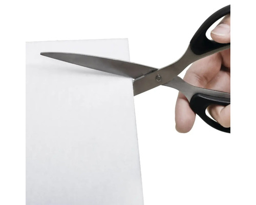 Ruka strihá list nožnicami.