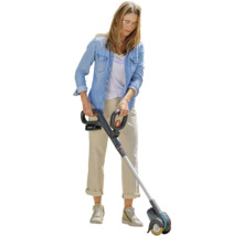 Žena používa akumulátorový čistič škár v záhrade.