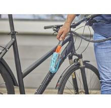 Osoba čistí bicykel kefou.