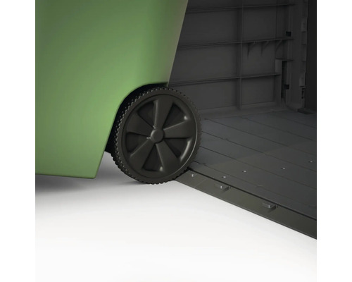 Detailný záber zeleného kontajnera na odpad s kolieskami stojaceho v šedom záhradnom domčeku