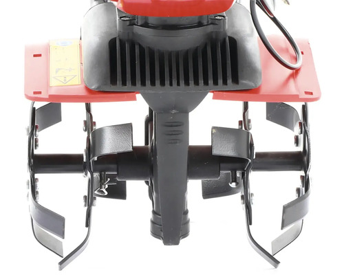 Detail záberu nožov motorového kultivátora do záhrady.