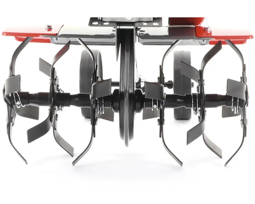 Detailný pohľad na motorový kultivátor s frézovacími nožmi a kolesami.