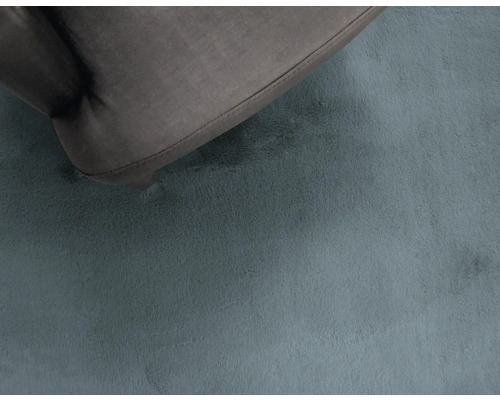 Detailný záber koberca s krátkym vlasom pod nábytkom