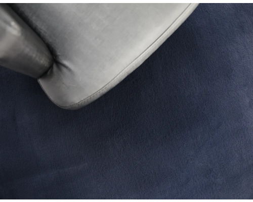 Detailný záber šedej stoličky na modrom koberci