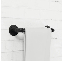 Držiak na uteráky z kovovej rúrky s uterákom na tehlovej stene