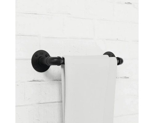 Držiak na uteráky z kovovej rúrky s uterákom na tehlovej stene