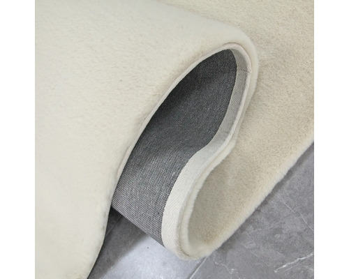 Detailný pohľad na svetlý koberec s vlasom a tkanou rubovou stranou