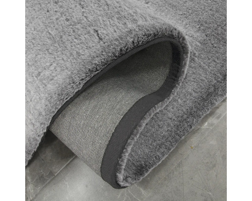 Sivý koberec s vysokým vlasom a textilným podkladom