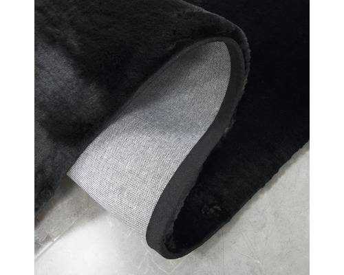 Čierny koberec s vysokým vlasom a textilným podkladom