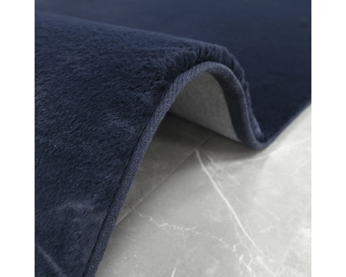 Detailný pohľad na tmavomodrý koberec s jemnou štruktúrou