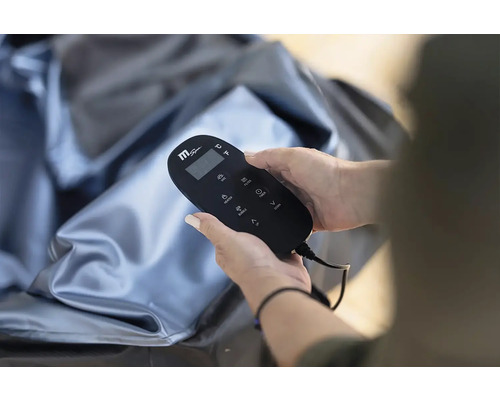 Osoba drží diaľkové ovládanie MSpa nad nafukovacou vírivkou