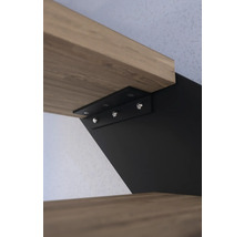 Detailný záber upevnenia drevenej police s čiernym držiakom