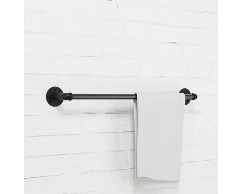Držiak na uteráky z kovovej rúrky s uterákom na tehlovej stene