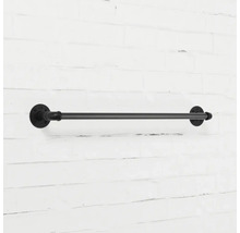 Čierny kovový držiak na uteráky na tehlovej stene