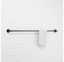 Čierny držiak na uteráky s uterákom na bielej stene