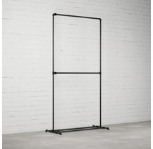 Stojan na šaty z rúrok v industriálnom dizajne pred tehlovou stenou