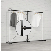 Vešiak na odevy z kovových rúrok s oblečením na drevených vešiakoch