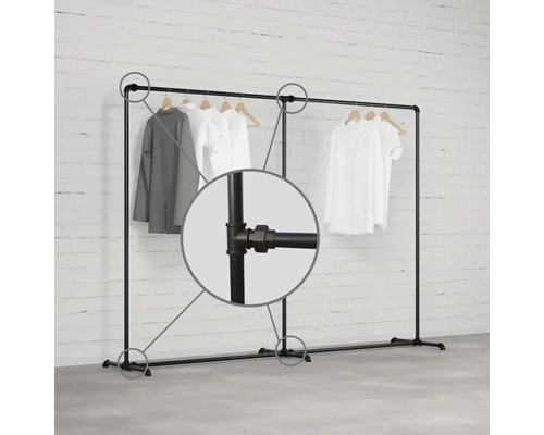 Vešiak na odevy z kovových rúrok s oblečením na drevených vešiakoch