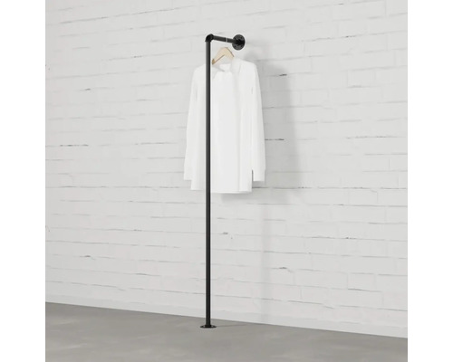 Čierny kovový vešiak na oblečenie s košeľou pripevnenou k stene.