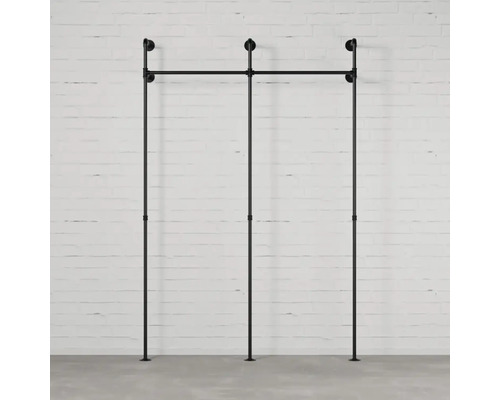 Čierny modulárny regálový systém pred tehlovou stenou