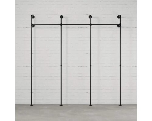 Vešiak na oblečenie z rúrok pred stenou