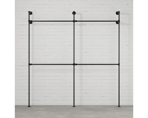 Voľne stojaci vešiak na oblečenie z kovových rúrok pred stenou