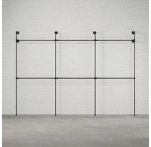 Čierny rúrkový systém vešiaka na šaty pred tehlovou stenou