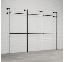 Čierny oceľový rúrkový šatníkový systém pred tehlovou stenou