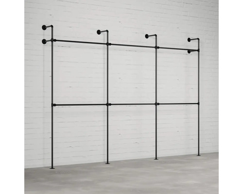 Čierny oceľový rúrkový šatníkový systém pred tehlovou stenou