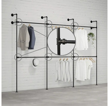 Stojan na šaty z rúrok pred tehlovou stenou s odevmi a detailným záberom na rúrkové spoje