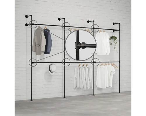 Stojan na šaty z rúrok pred tehlovou stenou s odevmi a detailným záberom na rúrkové spoje