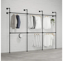 Voľne stojaci systém vešiakov na šaty s niekoľkými kusmi oblečenia, klobúkom a rastlinou