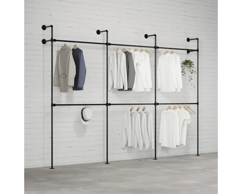 Voľne stojaci systém vešiakov na šaty s niekoľkými kusmi oblečenia, klobúkom a rastlinou