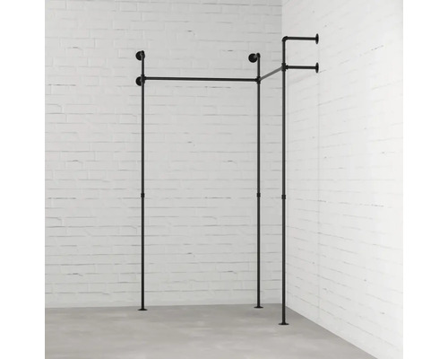 Vešiak na oblečenie z kovových rúrok pred stenou