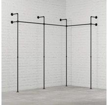 Vešiak na šaty z rúrok v rohovej izbe pred tehlovou stenou