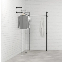 Čierny kovový rúrkový vešiak na oblečenie v rohovej izbe s oblečením