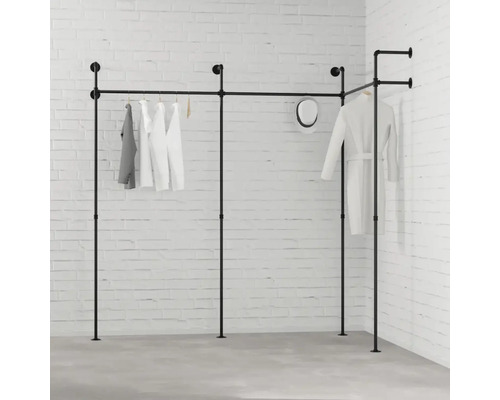 Čierny šatníkový systém s oblečením pred bielou tehlovou stenou